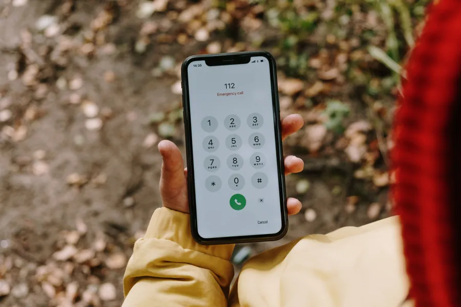 Main tenant un smartphone affichant le clavier de l'application Téléphone