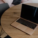 MacBook posé sur une table ronde en bois
